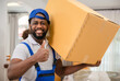 © Apiwan - Portrait of happy African delivery man worker in uniform standing carrying the box on the shoulder with looking at camera in the customer home.