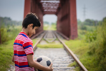 Wall Mural - Boy with football on railway track