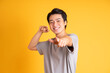 Asian young man posing on a yellow background