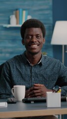 Poster - Vertical video: Portrait of charming handsome african american man smiling to camera, young black man in cozy modern flat apartment. Happy succesful attractive freelancer of african ethnicity. Slow