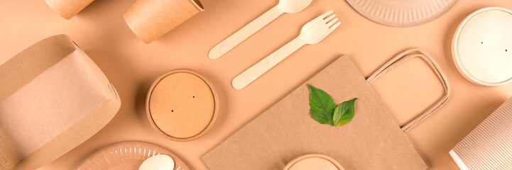 Banner with paper utensils and wooden cutlery set over light brown background. Street food sustainable paper packaging, zero waste packaging concept. Monochrome