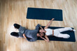 © Srdjan - Young happy married couple man and woman lying on the floor on yoga mats after home workout training. Positive active people in their apartment sweaty after exercising.