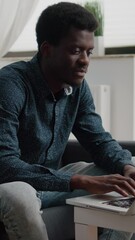 Poster - Vertical video: Working from home black man in flat apartment, happy african american remote worker using laptop computer, male workplace for online internet business, using social media