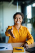 © Prostock-studio - Cooperation concept. Happy black businesswoman extending hand for handshake at camera, sitting at desk in office
