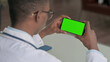 © stockbakers - Young African Doctor Looking at Smartphone with Chroma Screen