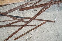 Iron Rusty Construction Rebars On Concrete Ground At Building Site Closeup Detail From Above