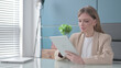 © stockbakers - Businesswoman using Tablet while Sitting in Office