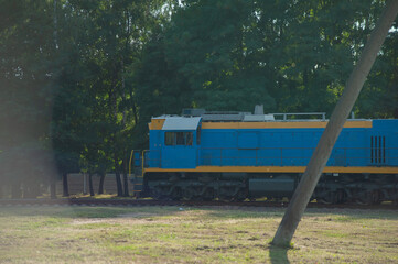 Wall Mural - Train locomotive rides on rails. Diesel freight train on railroad in motion. The head of a heavy diesel tractor locomotive for transporting train wagons