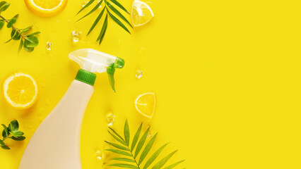 Wall Mural - Eco friendly natural cleaner, cleaning product, natural detergent bottle with green leaves and lemon slices on a yellow background with copy space. Mockup for natural detergents and cleaning products