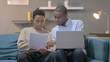 © stockbakers - African Couple with Laptop and Documents at Home