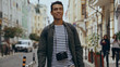 © LIGHTFIELD STUDIOS - Smiling bi-racial tourist with film camera walking on urban european street.