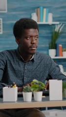 Poster - Vertical video: Authentic african american man computer user working from home in modern flat, remote black guy worker typing on computer, freelancer using internet from office. Online communication