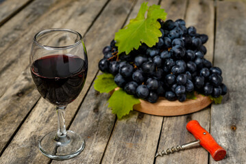 Wall Mural - Red wine and grapes on wooden background