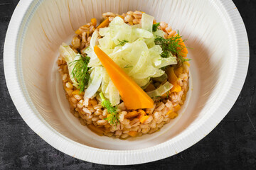 barley with pumpkin and fennel. a vegan dish in a plastic takeout container