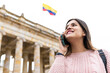 girl talking on the cell phone with a colombian flag in the background