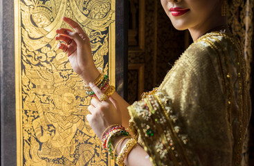 Wall Mural - Cropped image of Thai woman in traditional dress costume in Wat Phra Khao, Ayutthaya province, Thailand. Choose focus on hand