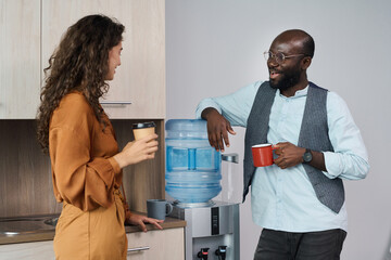 Aufkleber - Happy young intercultural office workers chatting and having tea and coffee at break while standing by water dispenser with gallon