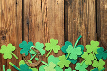 Flat Lay Composition With Clover Leaves And Horseshoe On Wooden Background, Space For Text. St. Patrick's Day
