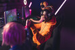 © PoppyPix - Three teenagers wearing colorful clothes playing online game using professional gaming setup celebrating victory in tournament with fist bumps. Color neon lights. Indoor shot. High quality photo