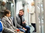 Fototapeta  - Happy passengers flirting in subway and smiling