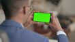 © stockbakers - Young African Businessman Looking at Smartphone with Chroma Screen