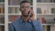 © stockbakers - Young African Man Talking on Phone