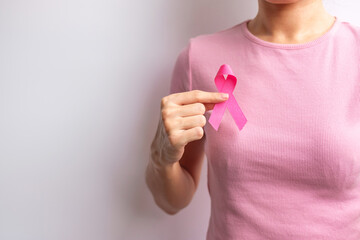 Wall Mural - Pink October Breast Cancer Awareness month, woman hand hold pink Ribbon and wear shirt for support people life and illness. National cancer survivors month, Mother and World cancer day concept