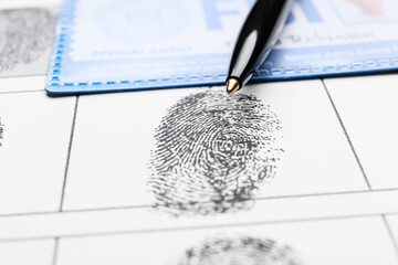 Wall Mural - Paper sheet with finger prints, pen and FBI agent's document, closeup