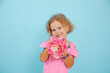 © Татьяна Волкова - Charming little girl show beautiful floral craft on empty blue background, free copy space. Blue eyed child of kindergarten age hold paper pink flower. Children creativity and fantasy