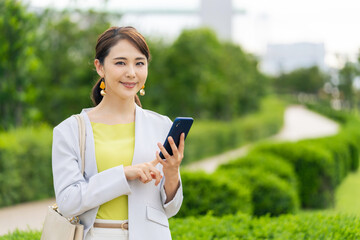Poster - 公園でスマホを使う女性　モバイル通信　SNS