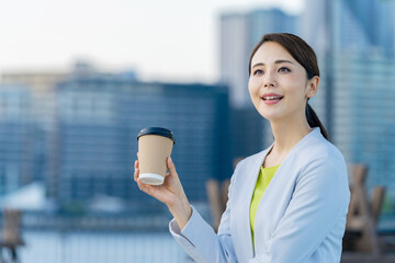 Poster - 都市の前で飲み物を飲む女性