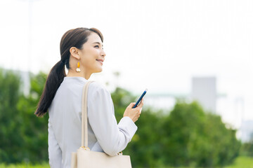 Poster - 公園でスマホを使う女性　モバイル通信　SNS