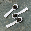 Black Caviar in special Shell Spoon on gray stone slate background texture