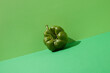 canvas print picture - Fresh green pepper on green background. Tilted angle view. Minimal concept.