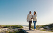 © Jacob Lund - Romantic senior couple walking down a foot bridge at the beach
