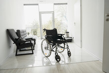 Modern Wheelchair In Empty Hospital Hall. Medical Equipment. High Quality Photo
