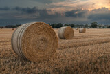 Fototapeta  - Straw bales in a field at sunset