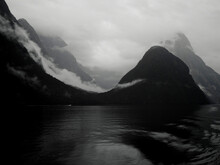 A View Of Milford Sound On A Rainy Day With Boat In Background