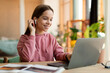 © Prostock-studio - Portrait of positive teen girl in earpods using laptop, studying online at home, happy schoolgirl looking at pc screen
