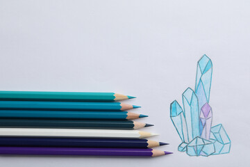 Poster - Drawing of crystals and colorful pencils on white background, top view