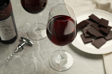 Wall Mural - Glass of red wine with chocolate on light marble table