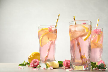 Sticker - Delicious refreshing drink with rose flowers and lemon slices on light grey table