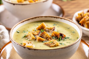 Wall Mural - Garlic cream soup with bread croutons in rustic bowl - Close up