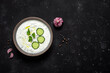 Greek tzatziki sauce on black stone background. View from above, flat lay