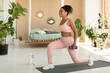 Healthy lifestyle. Fit african american woman doing forward walking lunges with dumbbells, exercising at home