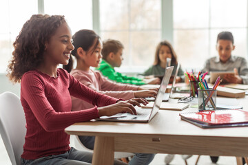 Aufkleber - Black Schoolgirl Using Laptop Sitting With Multiethnic Classmates In Classroom