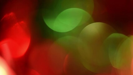 Wall Mural - Christmas bokeh motion. Red and Green defocused circles shimmer, shine and sparkle. Lens effect. Can be used as background, overlay or screen. New Year's lights.