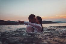 Romantic Couple Kissing In The Sea At Sunset. High Quality Photo