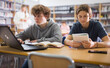 © JackF - Portrait of two focused schoolchildren doing homework in the school library, sitting at a desk in front of a laptop