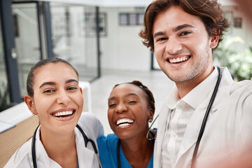 Wall Mural - Healthcare, hospital and doctors taking selfie, bonding while working together and having fun. Medical intern posing for a picture, smiling and laughing, enjoying diverse friendship at the workplace